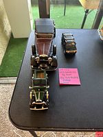 Top-down view showing three model cars arranged on table, including 1932 Lincoln KB convertible, 1931 Ford Model A Pickup, and a smaller black Hummer RM model car.