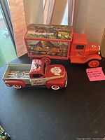 Both model trucks displayed on table, red Ohio State Buckeye pickup and orange Allis-Chalmers truck visible