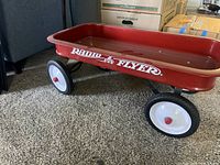 Side view of the red Radio Flyer wagon showing the logo and wheels.