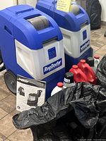 Front view of Rug Doctor Mighty Pro X3 machine with solution jugs and manual