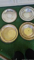 Four vintage silver plated serving trays and bowls with decorative edges and patina, in varying sizes
