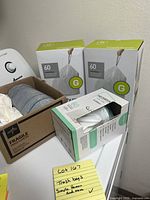 Photo showing two unopened boxes of Simplehuman trash bags Size G and one open box with a roll of trash bags in a cardboard box labeled fragile.