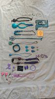 All jewelry pieces laid out on a light cloth, showing turquoise, pink, purple, and white items including necklaces, earrings, bracelet, and clips.