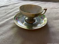 Side view of the Del Mar cup and saucer showing floral design, gold trim, and iridescent cup interior.