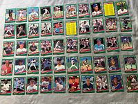 Top view of 36 DonRuss baseball cards arranged in rows on a cloth surface, showing front side with player images and colorful borders.