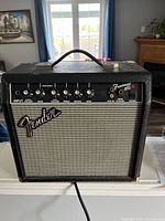 Front view of Fender Frontman 15G amplifier showing control knobs, input and output jacks, power switch and Fender logo.