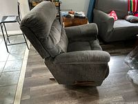 Side view of gray/blue Lazy Boy recliner chair showing fabric upholstery and wooden recline lever