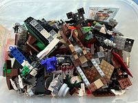 Photo of various loose mixed LEGO pieces in a plastic container