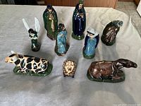 Full set of 9 nativity scene figurines arranged on a table showing all characters and animals.