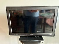 Front view of Sony KDL-32LL150 TV showing screen and front bezel with Sony logo and button controls.