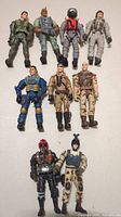 Full group photo of nine action figures arranged in three rows with various military uniforms and styles.