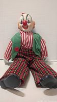 Clown doll sitting, showing face, clothes, and shoes