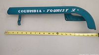 Full length view of the blue Columbia Tourist V chain guard with measuring tape beneath to show length of approximately 21 inches.