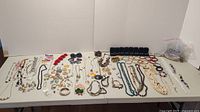 Assorted necklaces, bracelets, rings and earrings displayed on table