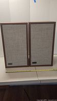 Front view of two KLH Model Six speakers with fabric grills on a table, measured about 23.5 inches tall.