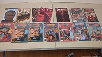 Photo showing the full lot of 16 comic books laid flat on a table, visible front covers.