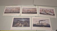 Five colored prints of various steamships laid out on a table showing large paddle wheel steamers, riverboats, and excursion vessels.