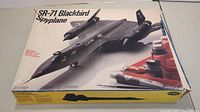 Photo of the box front of the Testors SR-71 Blackbird model showing the model plane and painting supplies, box worn and damaged but contents sealed.