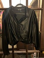Front view of DKNY faux leather shacket on hanger