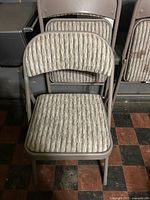 Front view of padded folding chair showing frame color and striped upholstery