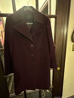 Full front view of plum Tahari coat on hanger