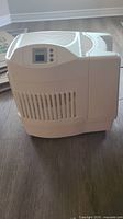 Full side view of the white electric Aircare humidifier showing vented body and curved top design.