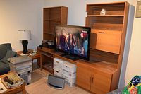full view of three-piece wall unit with TV and contents for scale
