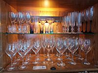 Upper and lower cabinet shelves showing entire variety of stemware and glassware