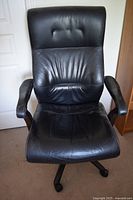 Front view of high-back black office chair showing seat, backrest, armrests and base