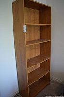 Front view of teak bookcase showing five shelves