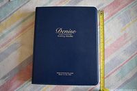 Closed navy Denise Interchangeable Knitting Needles binder beside measuring tape