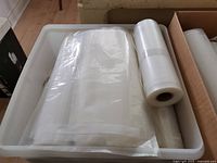 Clear textured vacuum-sealer roll and loose pouches in bin
