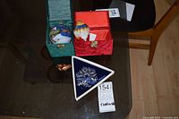 Three ornaments with their boxes on a table