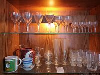 Cabinet showing grouped stemware, tumblers, and assorted bar pieces