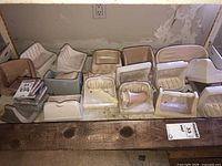 Various vintage and heavily used ceramic bathroom fixtures arranged on a wooden surface with marble pieces, showing dirt and wear.