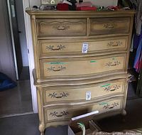 Front view of tall dresser showing two small top drawers, one mid-size drawer and two larger lower drawers, painted finish and decorative appliqués