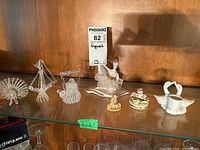 Photo showing the full collection on a wooden shelf including blown glass items, ballerina figurine, floral toothpick holder, and swans.