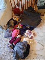 Full overview of winter hats, scarves, gloves, mittens, and two black suitcases.