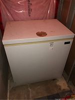 Full view of white Kenmore chest freezer with yellowing trim and worn spot on top lid.