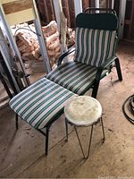 Lounger and round stool set placed in a unfinished indoor space with wooden floor and construction materials visible.