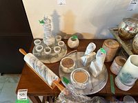 Full view of lot on table showing decanter set, rolling pin, bookends, coasters, container, candle holders