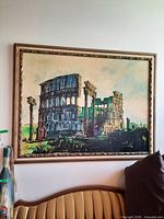 Full view of framed painting showing the Colosseum over a yellow-green background with black raised paint texture and detailed frame.