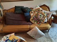 Sofa with multiple pillows and pillowcases showing colors and textures including embroidered floral pillow and solid color cushions.