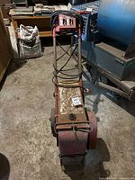 Front view of electric propelled paint stripper showing overall frame, control box on handle, and wiring.