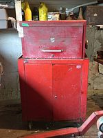 Front view of red metal tool chest including top chest and bottom cabinet