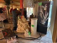 View of the lot with the religious figures, bisque vase, incense burner with incense, and floral light/music box arranged on a table.