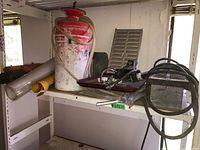 Paint sprayer with hose, trays and heater on metal shelf