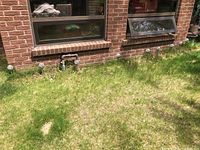 Steel garden area outside a brick house with 10 solar garden lights spaced in a line in the grass, showing configuration and quantity.