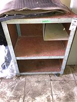 Full view of steel cabinet showing overall structure with two open shelves and a small side compartment on the top shelf.