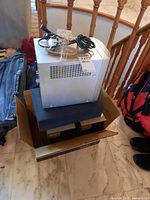 Photo of boxed stereo speakers with cables and cardboard box base